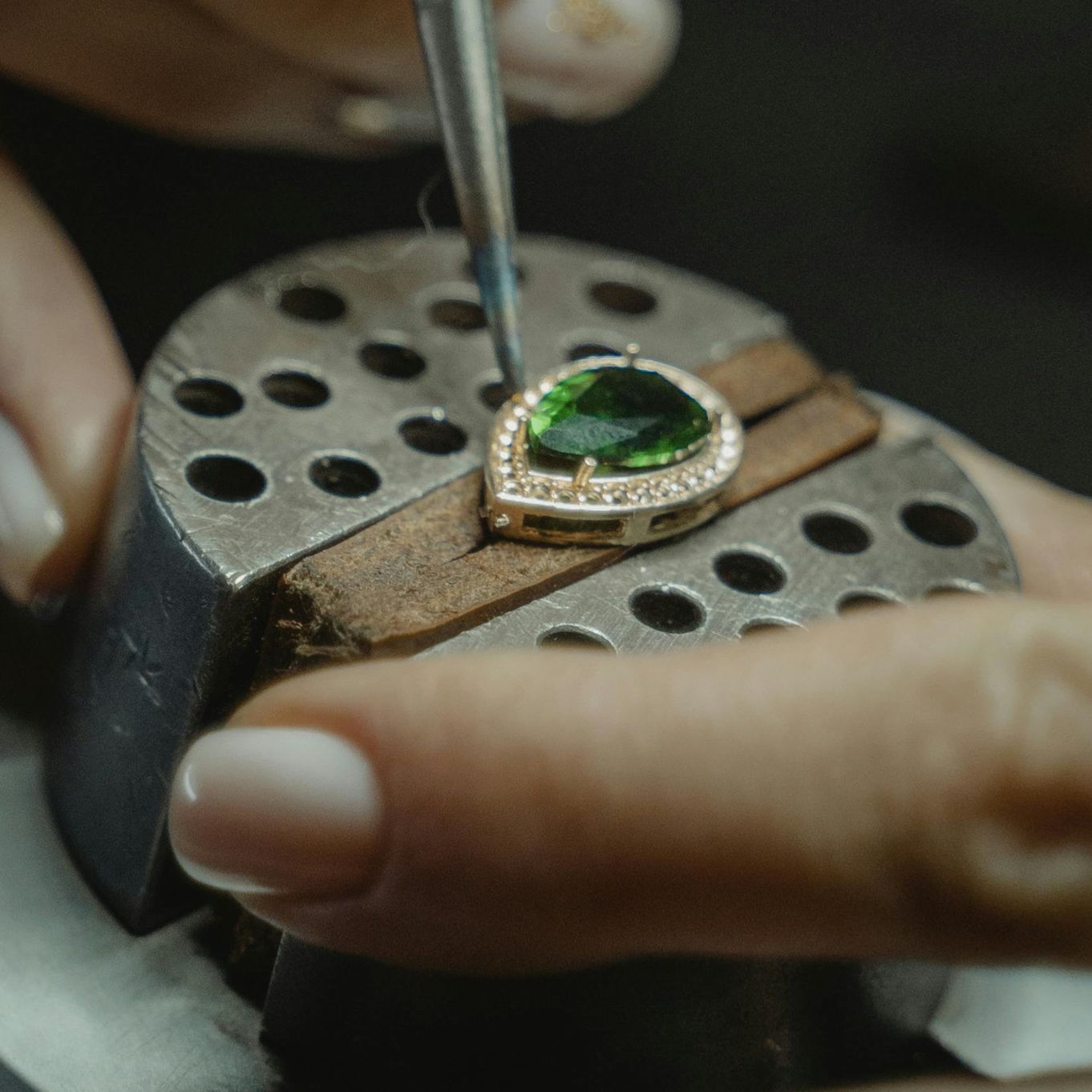 A ring in a vice being worked on with a tool