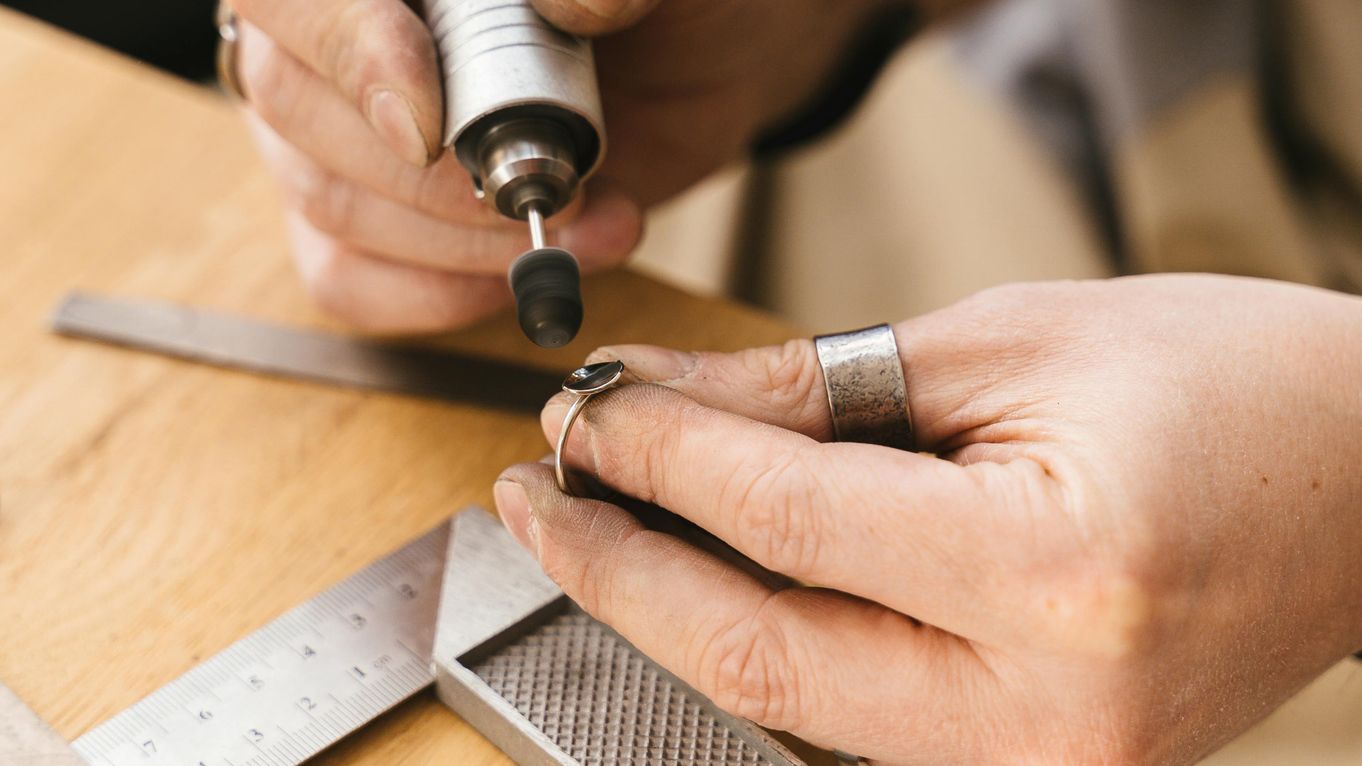 Hands using a motorised polisher on a ring without a gem