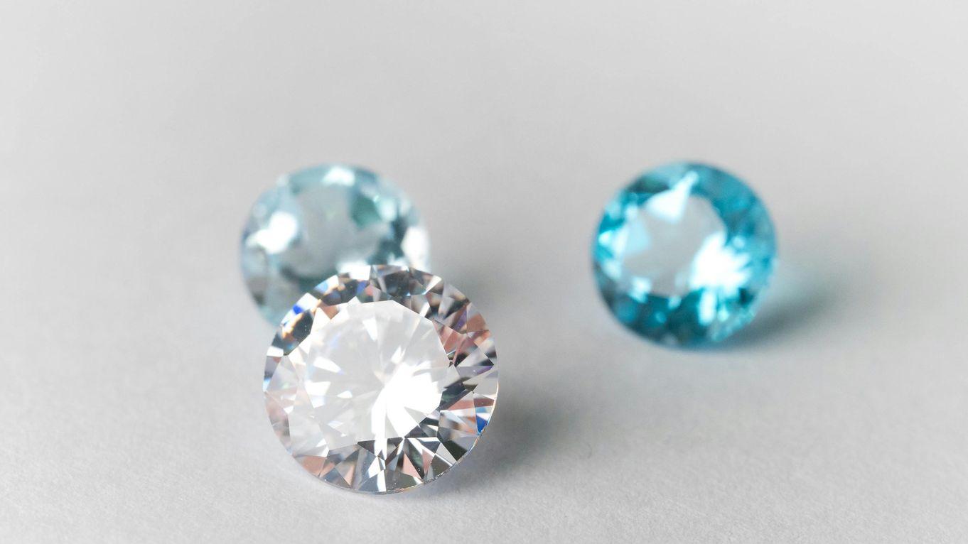 Three gemstones on a grey background